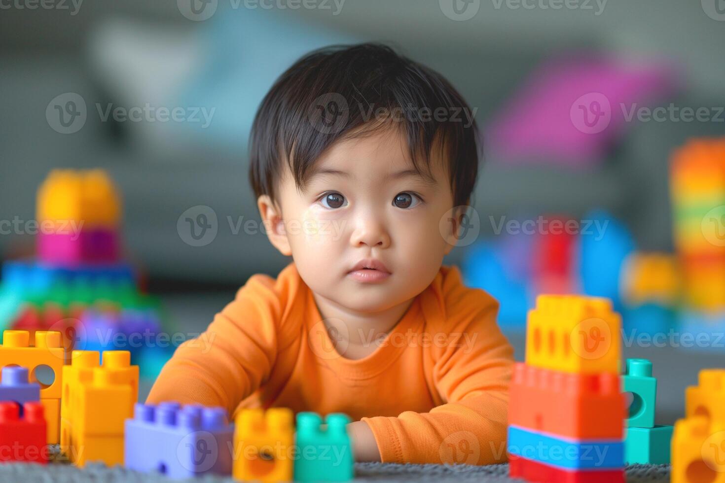 A curious Asian toddler plays with colorful building blocks, surrounded by a vibrant array of toys, capturing a moment of childhood wonder. photo