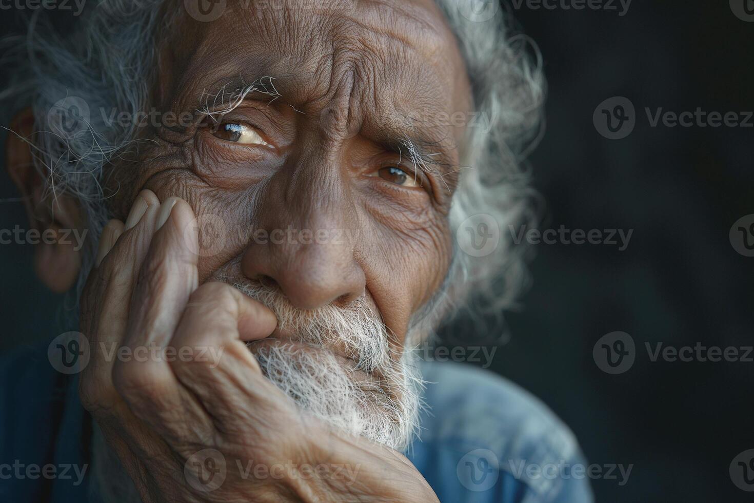 An elderly South Asian man deep in thought, showcasing intricate facial wrinkles and a contemplative expression. photo