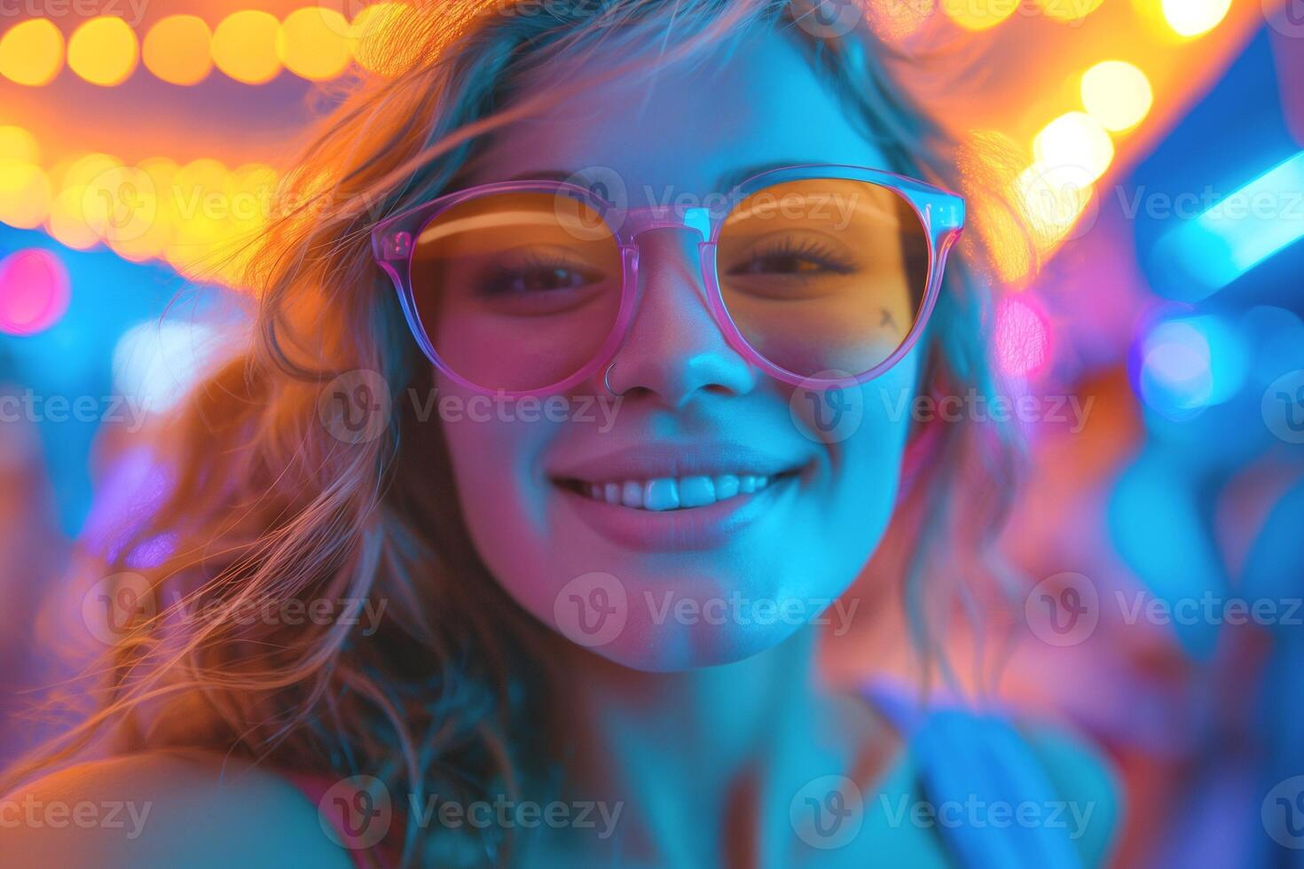 A smiling young woman with curly hair and colorful oversized glasses enjoys a festive atmosphere filled with vibrant neon lights. photo
