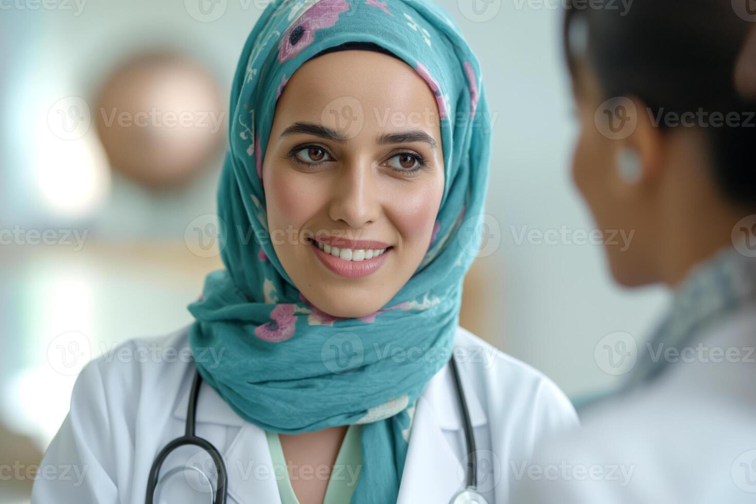 A confident Middle-Eastern female doctor in a hijab smiles warmly while conversing with a patient. photo