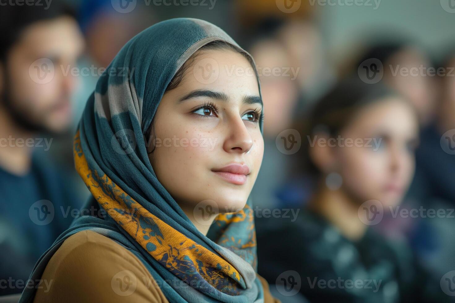A thoughtful young woman wearing a scarf engages in a discussion, her serene expression highlighting her focus. photo