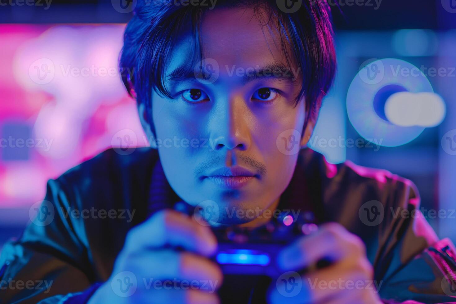 A focused young Asian male gamer holds a controller, surrounded by vibrant neon lights that create an energetic atmosphere. photo