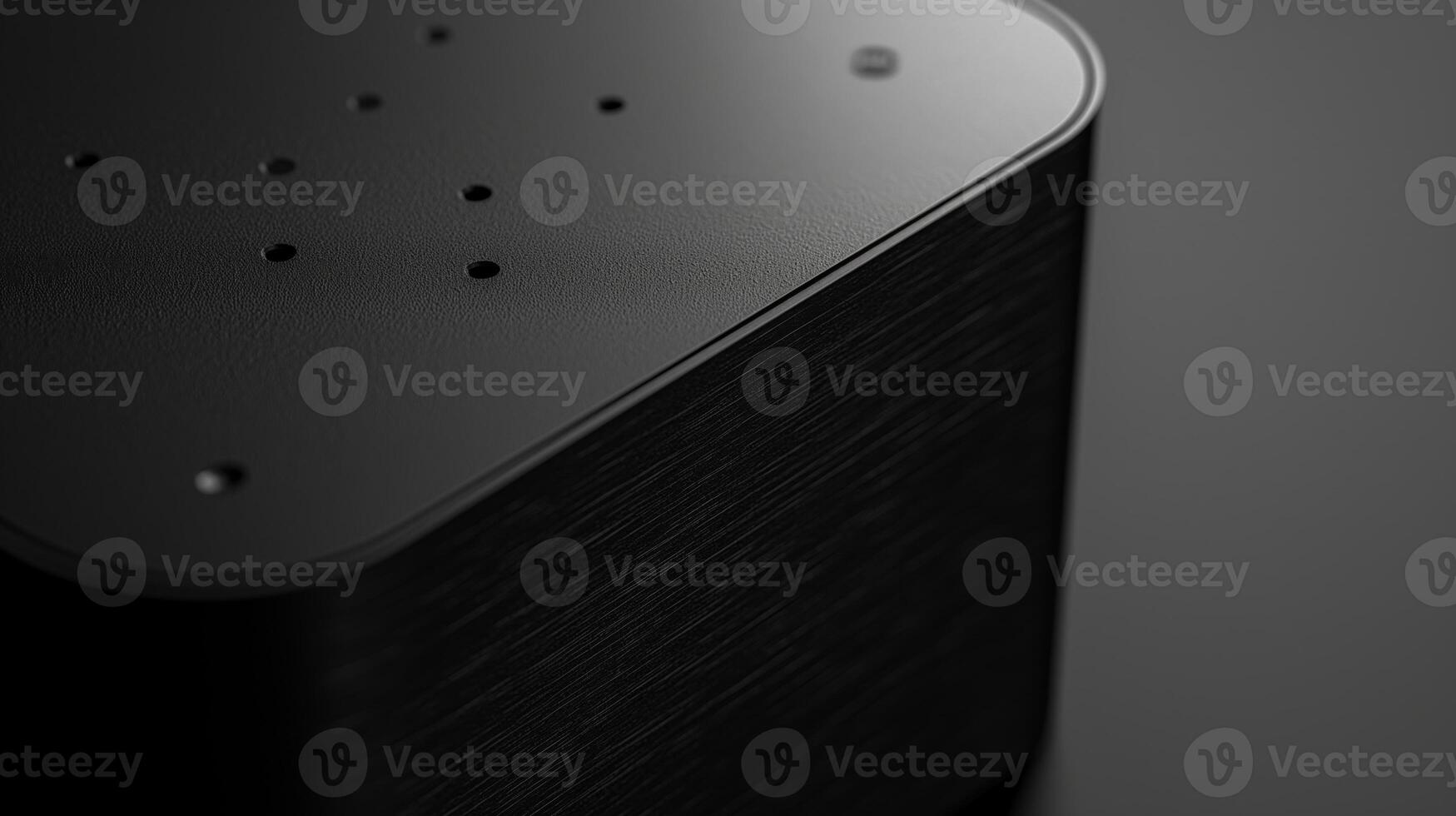 Close-up of a sleek black device with textured surface and small perforations, evoking a modern, high-tech aesthetic. photo
