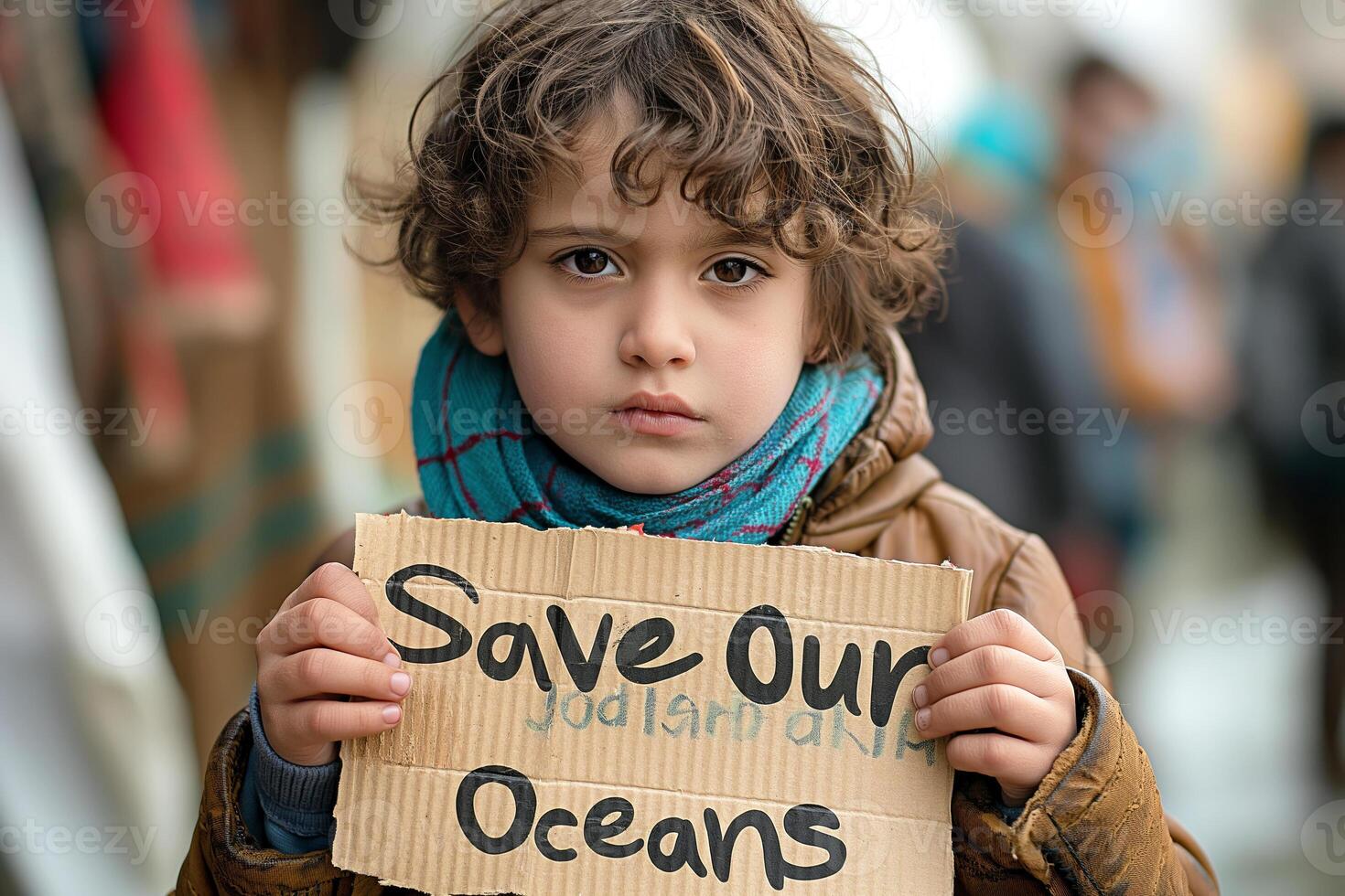 A young boy of Middle Eastern descent holds a handmade sign advocating for ocean conservation. photo