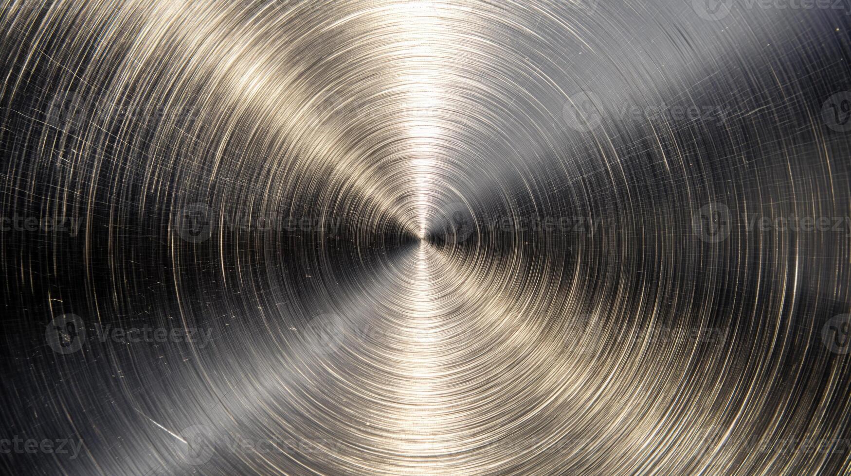 Close-up of brushed metal surface with swirling patterns, reflecting light beautifully. photo
