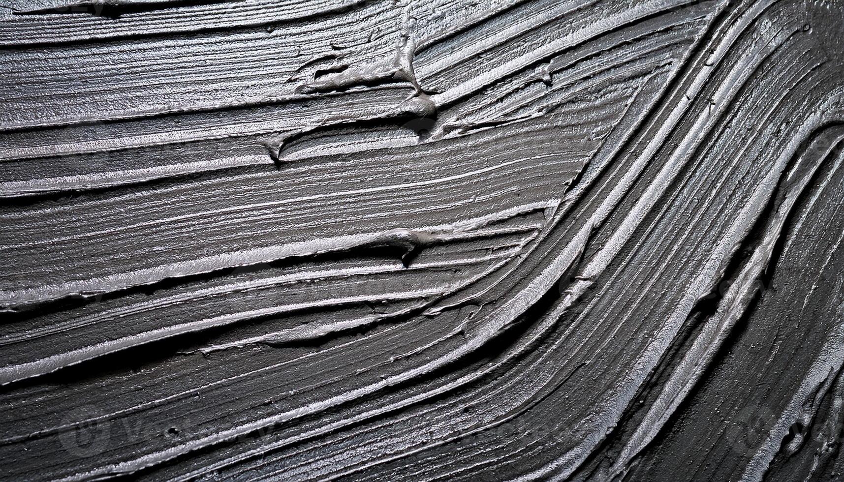 Black Textured Surface With Smooth Lines and Swirls Showing the Process of Applying Material in a Creative Project photo