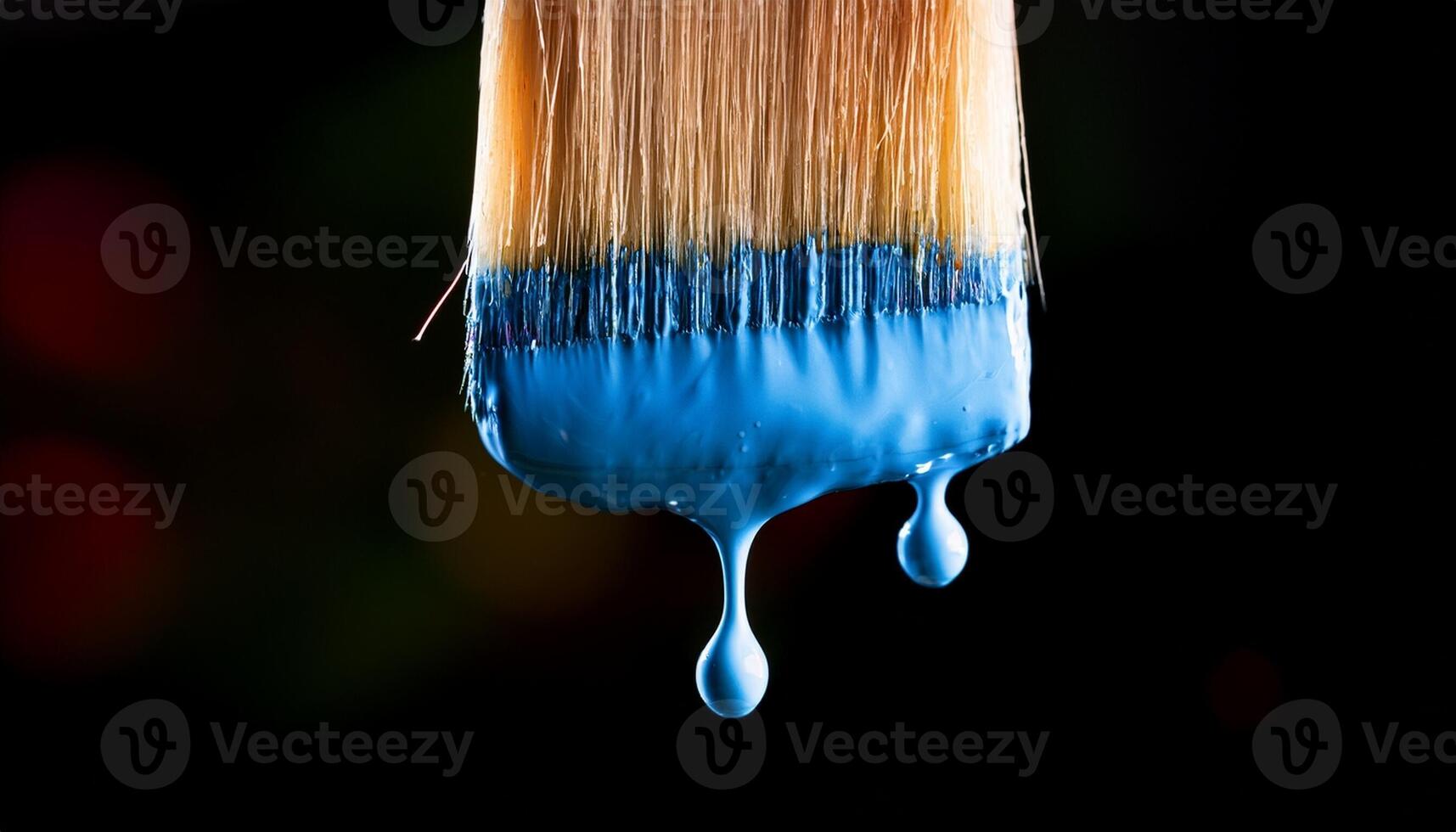 Paintbrush Dripping Blue Paint Against a Dark Background During an Artistic Project photo