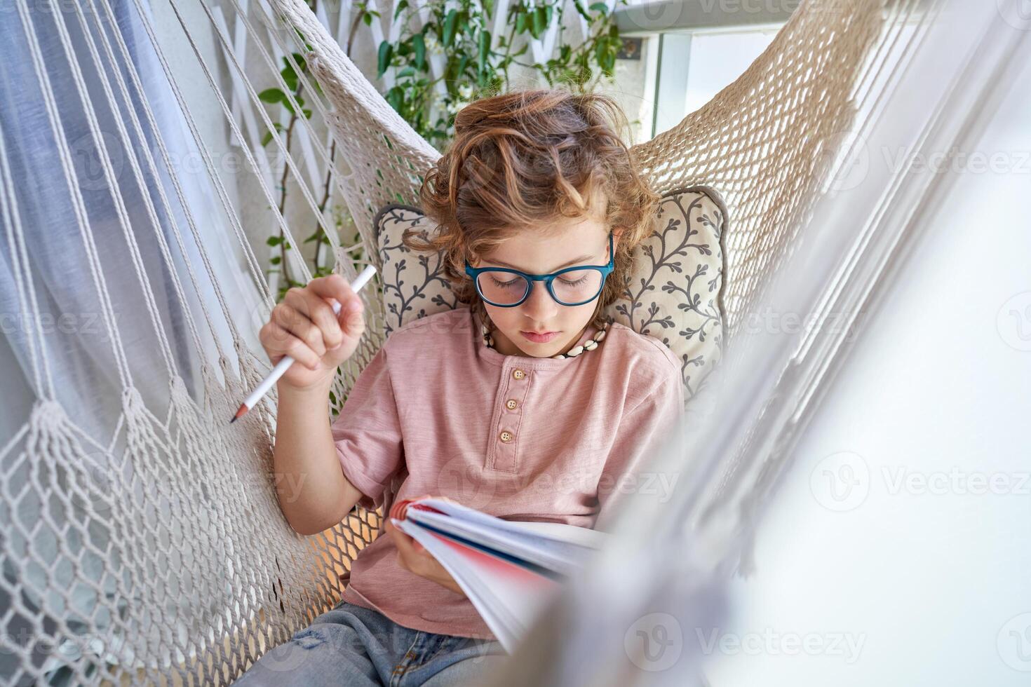Boy doing homework in hammock photo