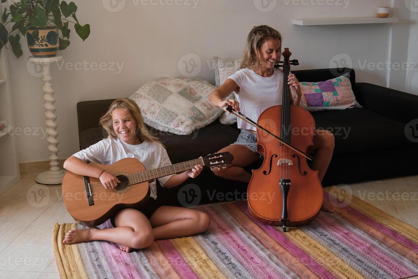 Mother and daughter playing musical instruments at home photo