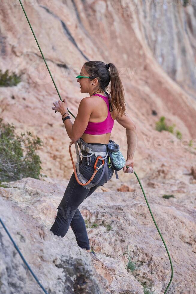 Female climber hanging on rope in mount photo