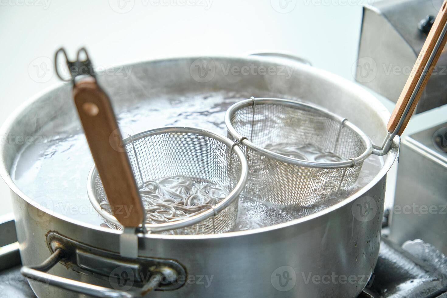 Buckwheat noodles cooking in big saucepan with hot water photo