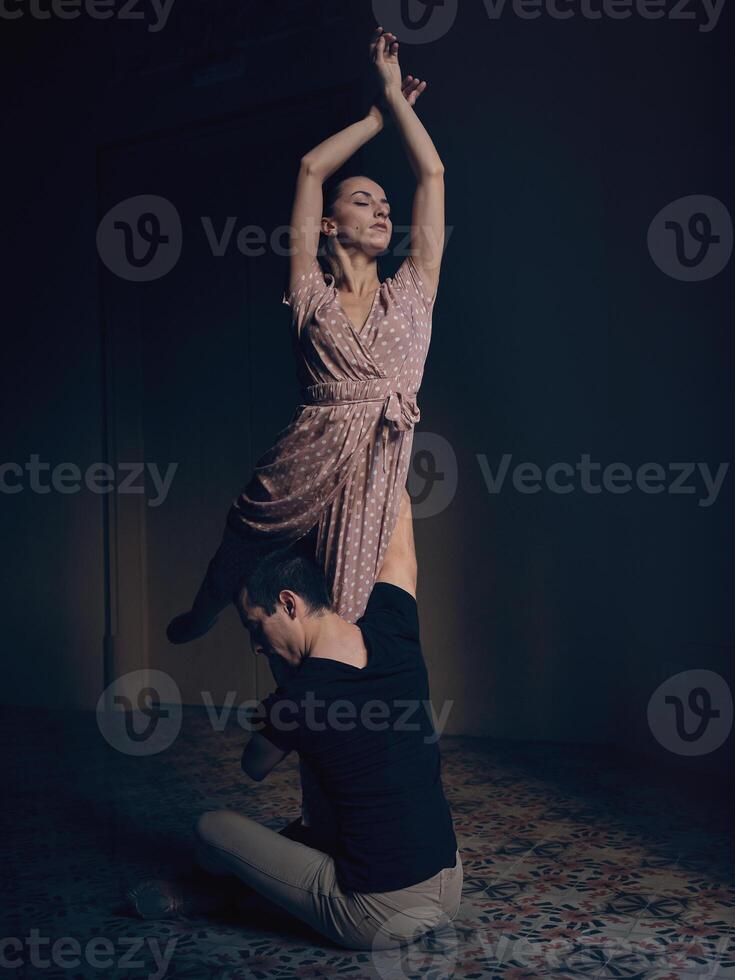 Graceful woman lifted by male in darkness photo