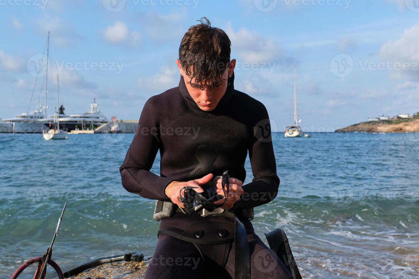 Serious man preparing for diving in sea photo