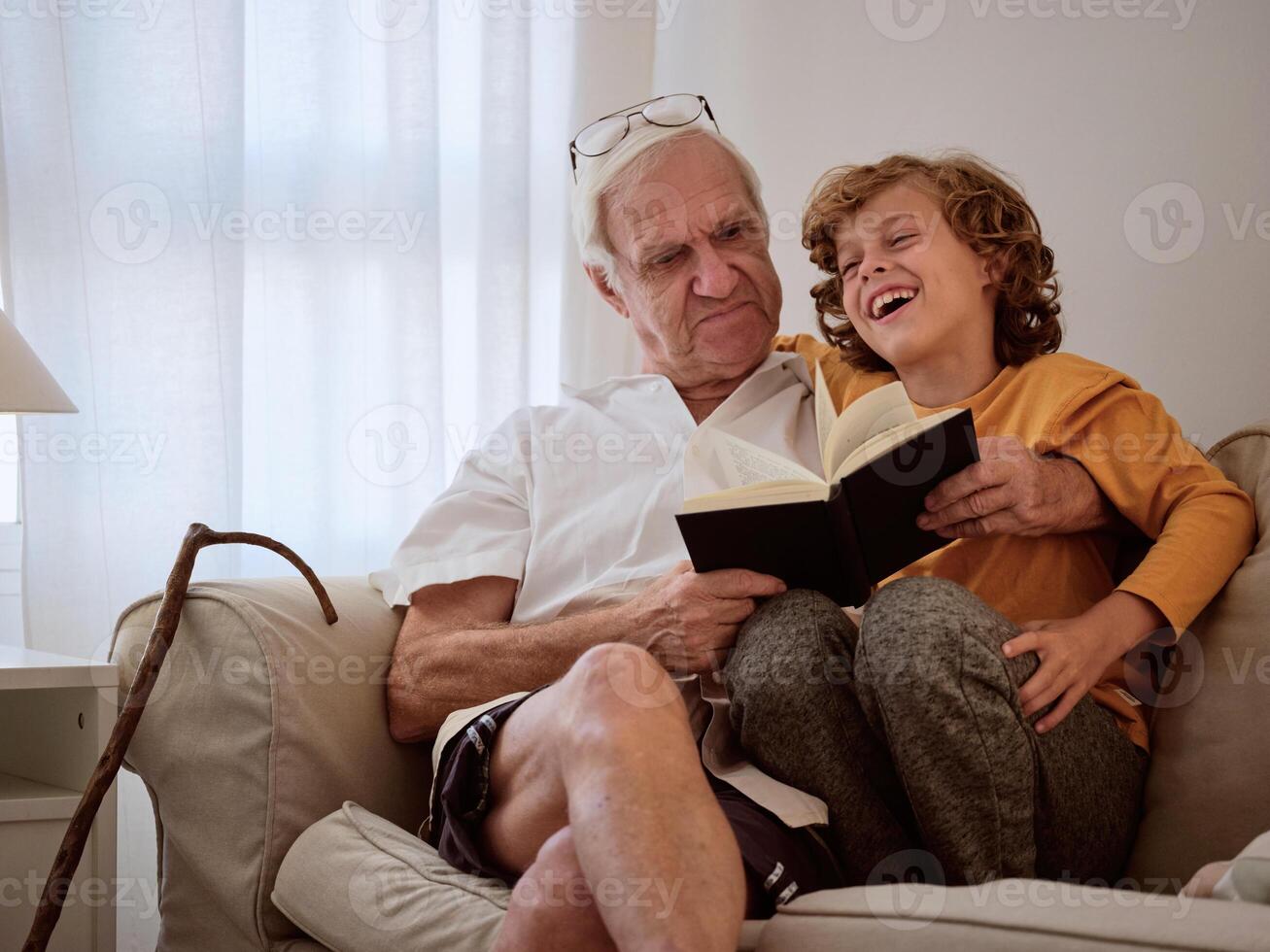 Grandfather and grandson spending time together reading book photo