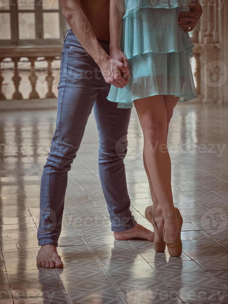 Lady in pointe shoes with partner in hall photo