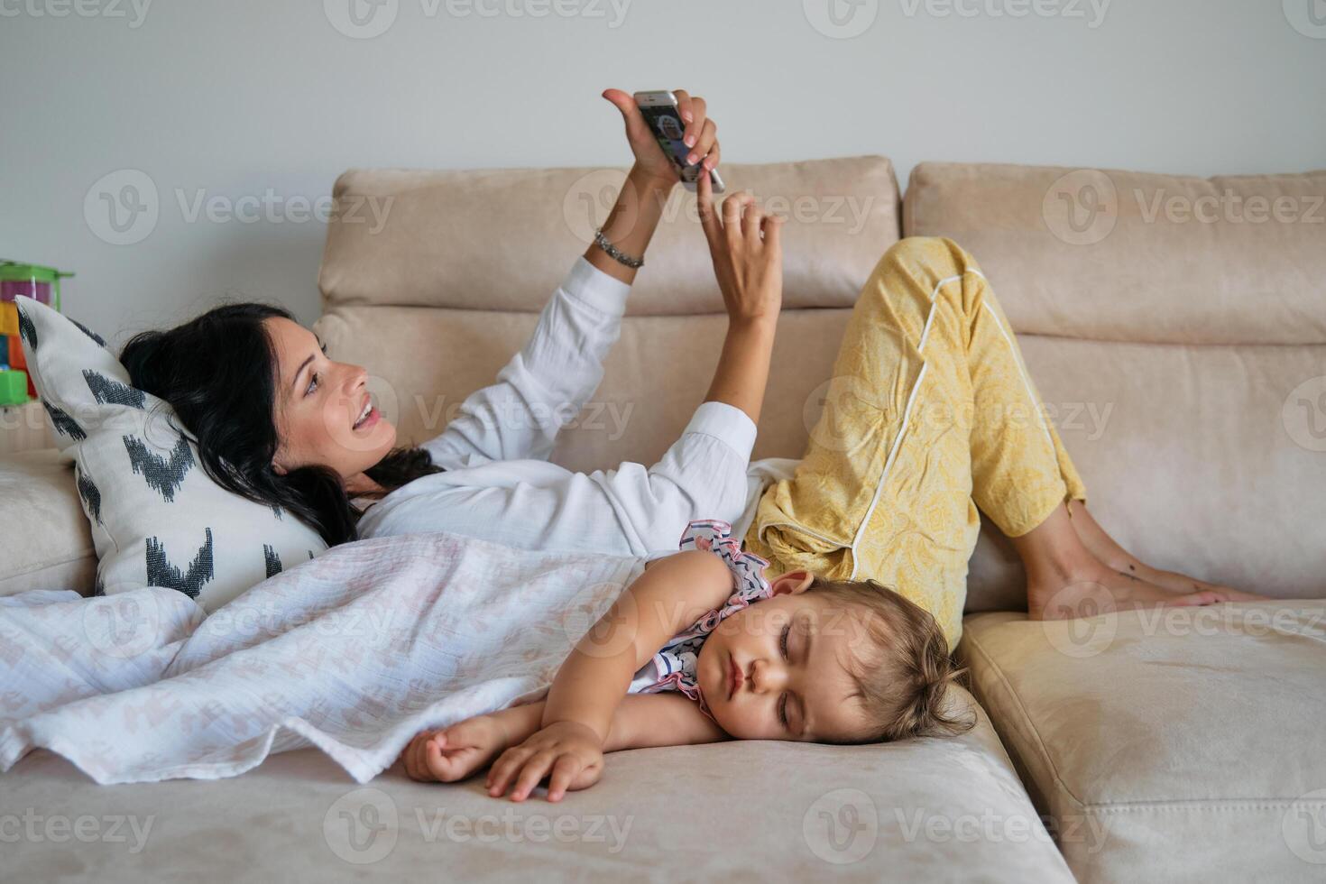 Woman and daughter relaxing on sofa at home photo