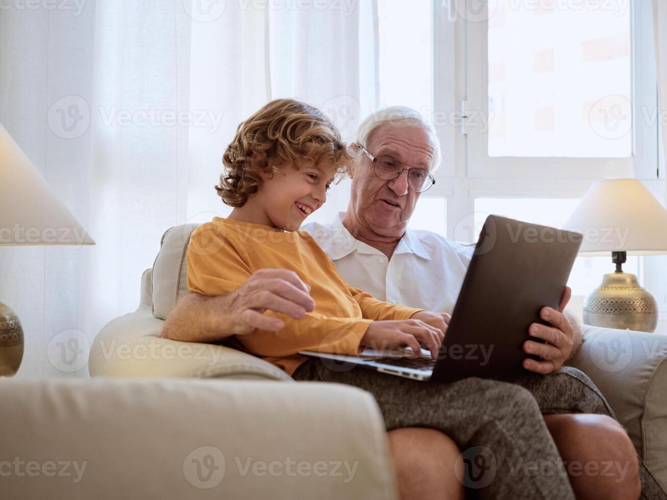 Happy grandfather and grandson watching on netbook photo