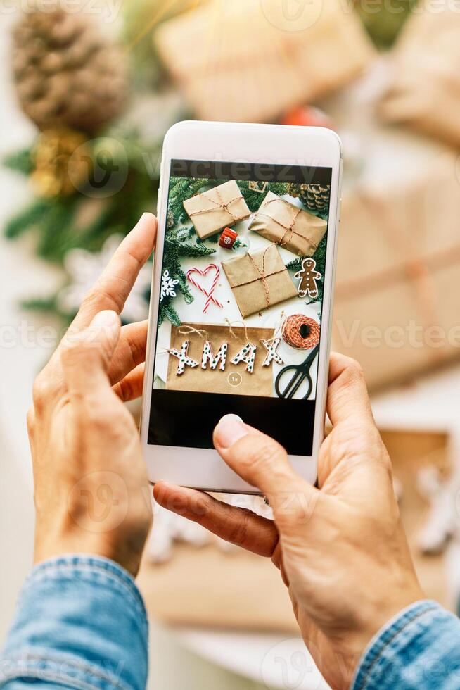 Anonymous person photographing Christmas presents on phone photo