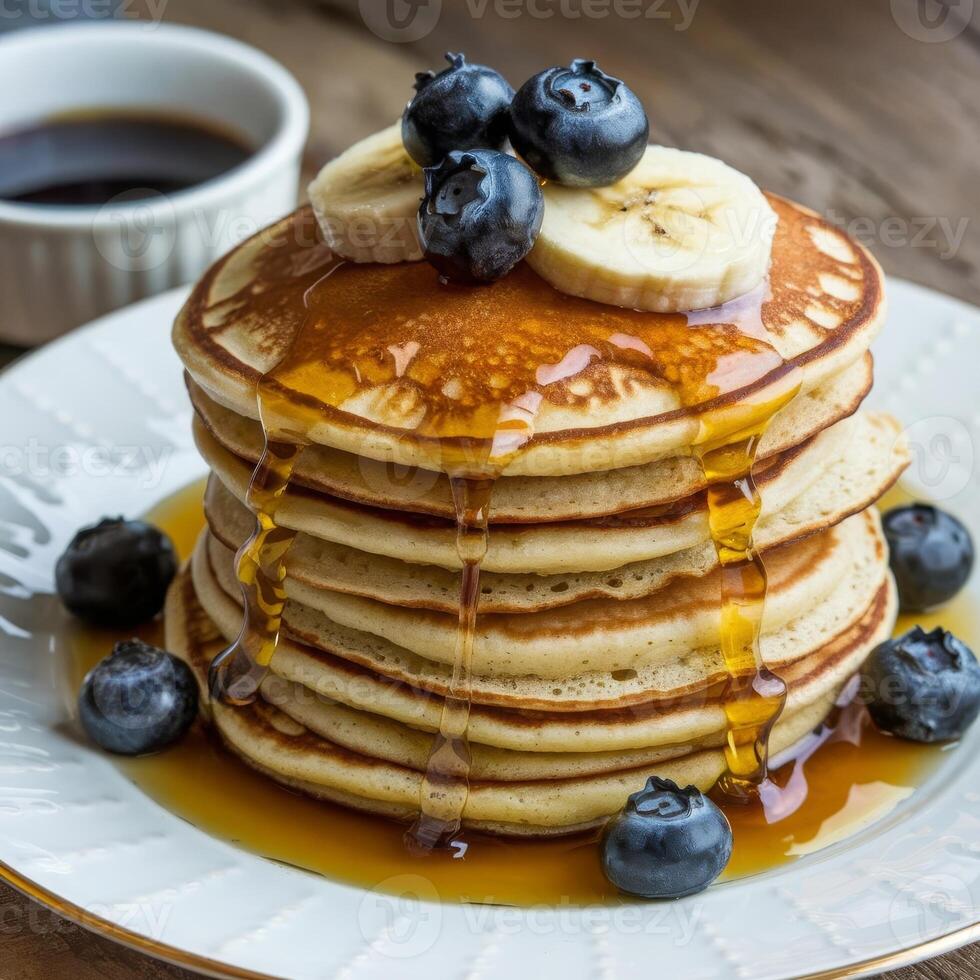 A stack of pancakes with blueberries and syrup photo