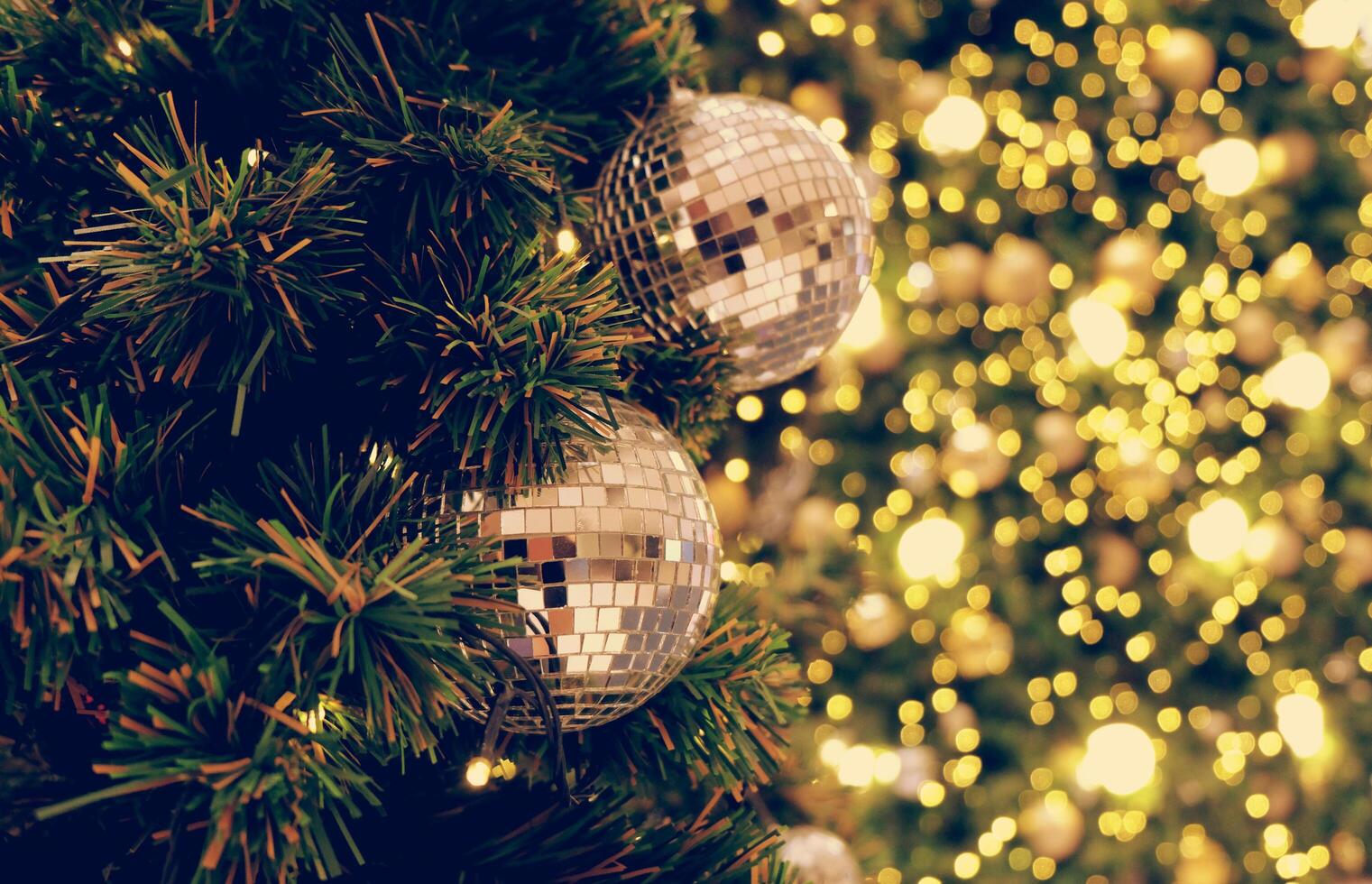 Gold holiday background of de-focused lights with decorated tree photo