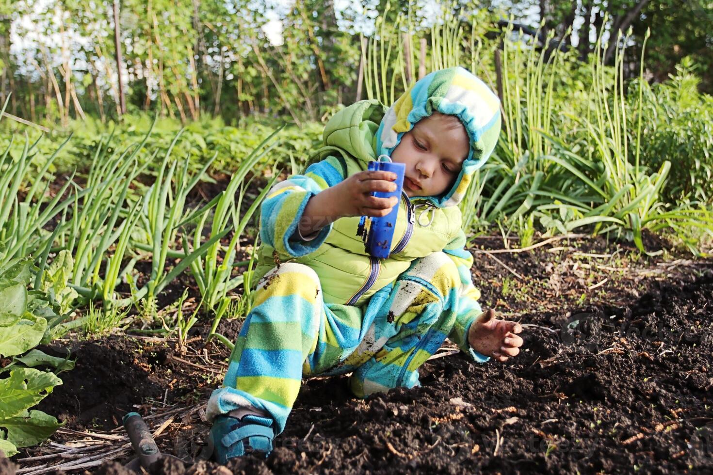 Funny Little Boy Playing In The Garden. photo