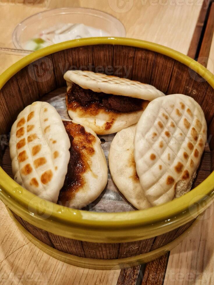 A bowl of steamed buns with meat and vegetables photo