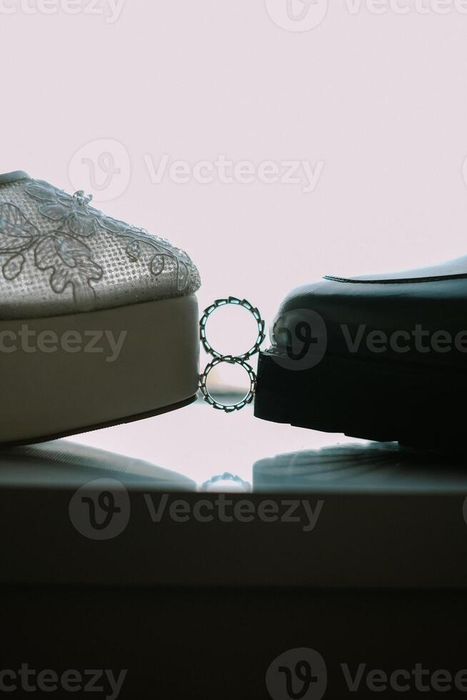 Bridal Shoes and Wedding Rings Together, Closeup of Groom and Bride Shoes photo