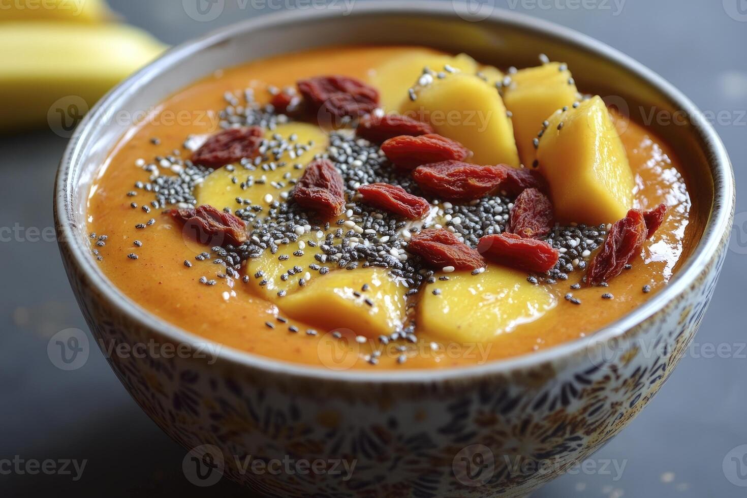 Enjoying Healthy Mango Smoothie Bowl Topped with Goji Berries and Seeds photo