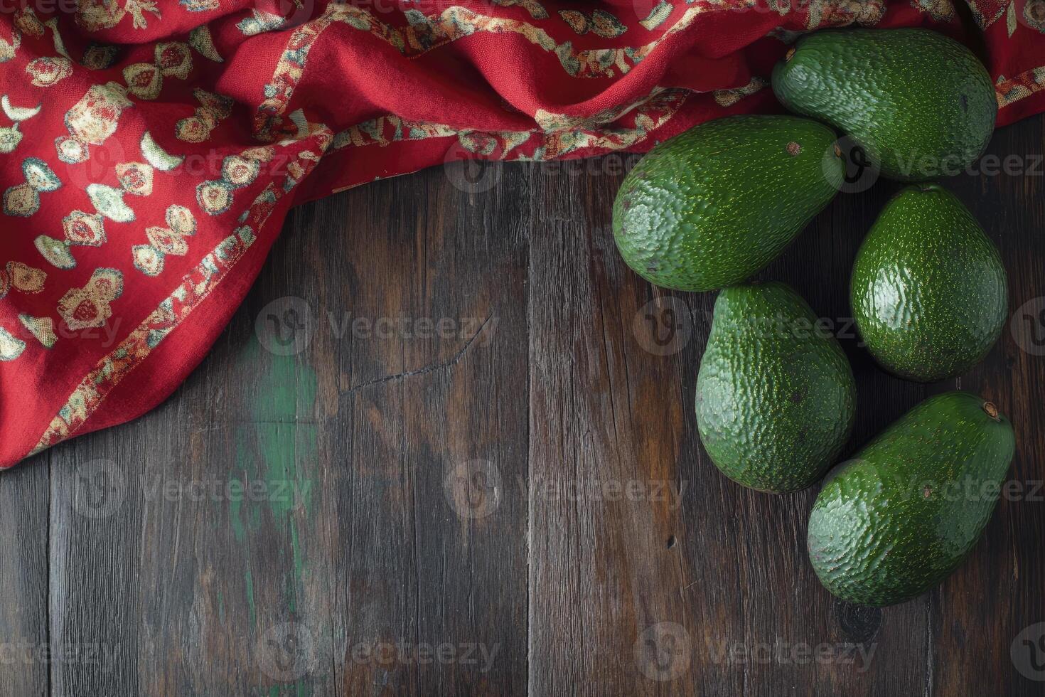 Arrangement of Fresh Avocados on Wooden Surface with Decorative Red Cloth photo
