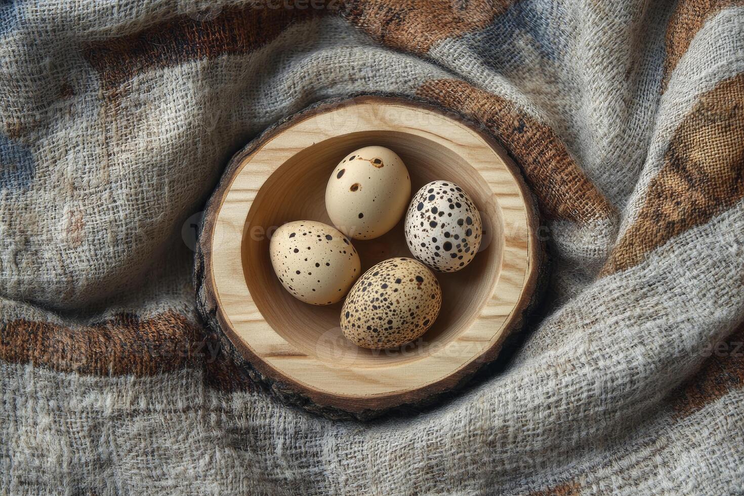 Speckled Eggs Resting in Wooden Bowl on Soft Woven Textile photo