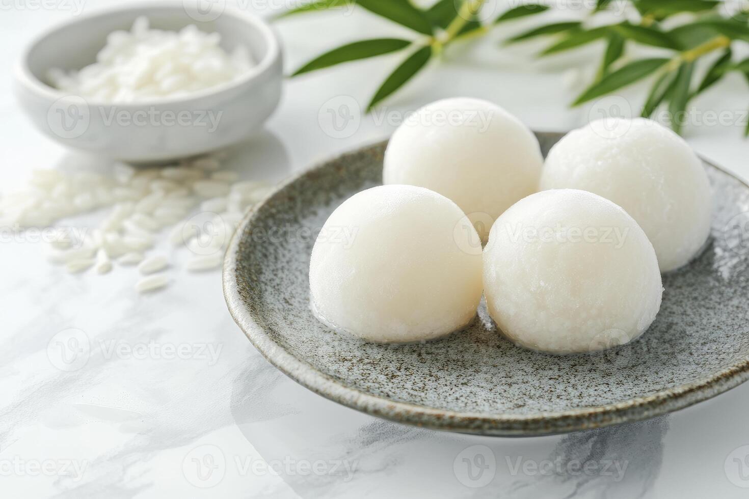 Serving of Mochi on Plate with Rice Bowl and Bamboo Leaves photo