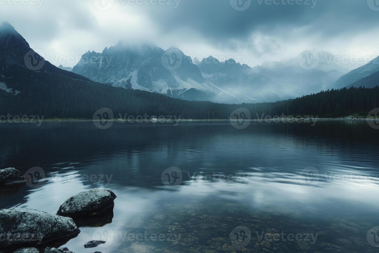 Calm Lake Reflecting Mountains and Forest Under a Cloudy Sky photo