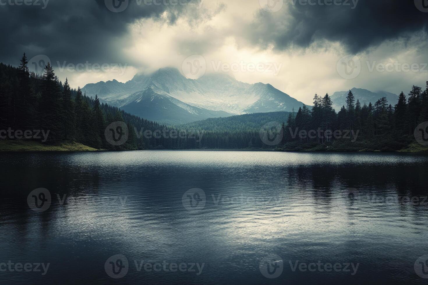 Serene Lake Surrounded by Forest and Mountains Under Moody Sky photo