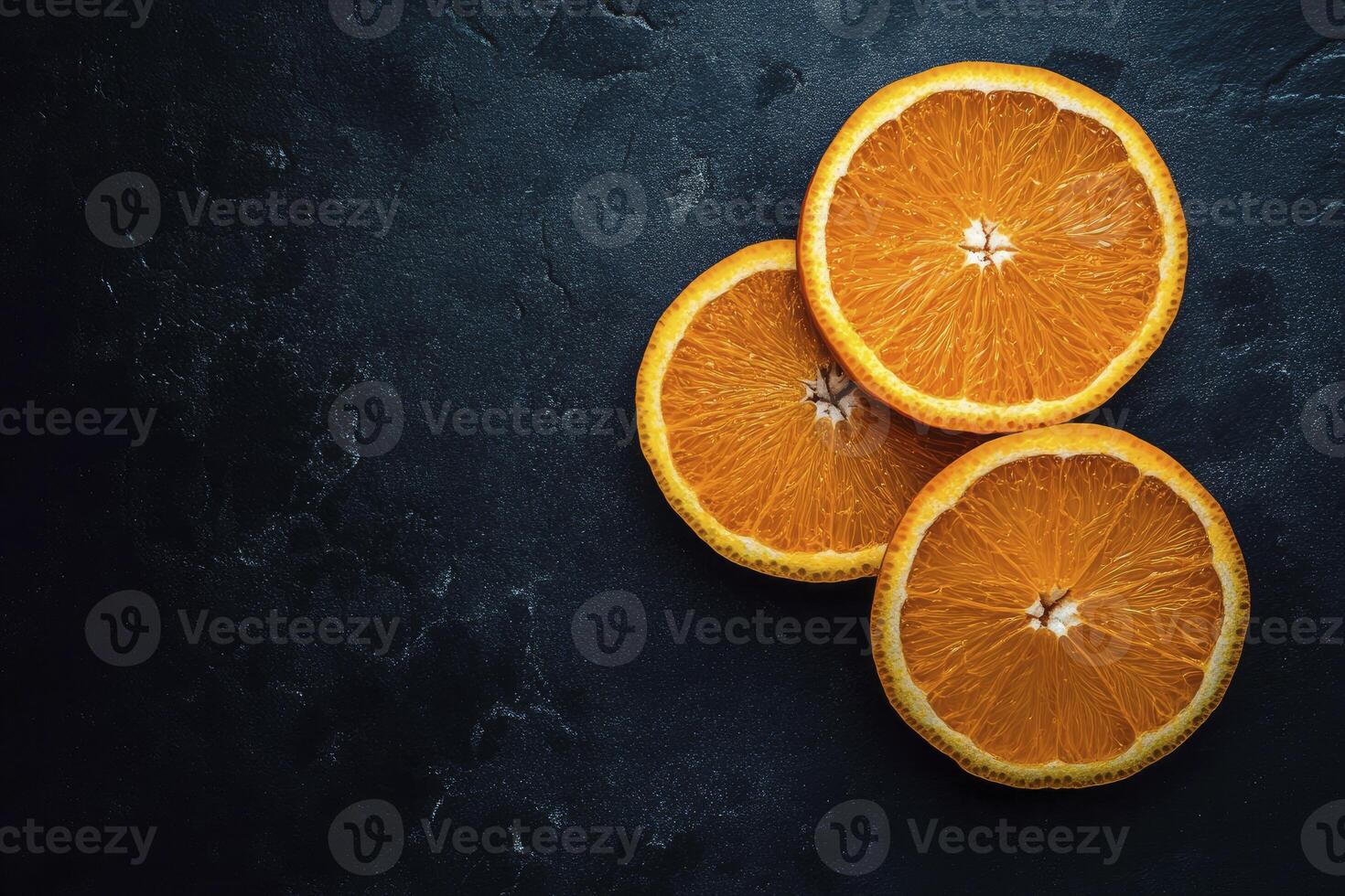 Arrangement of Fresh Orange Slices on a Dark Stone Surface photo