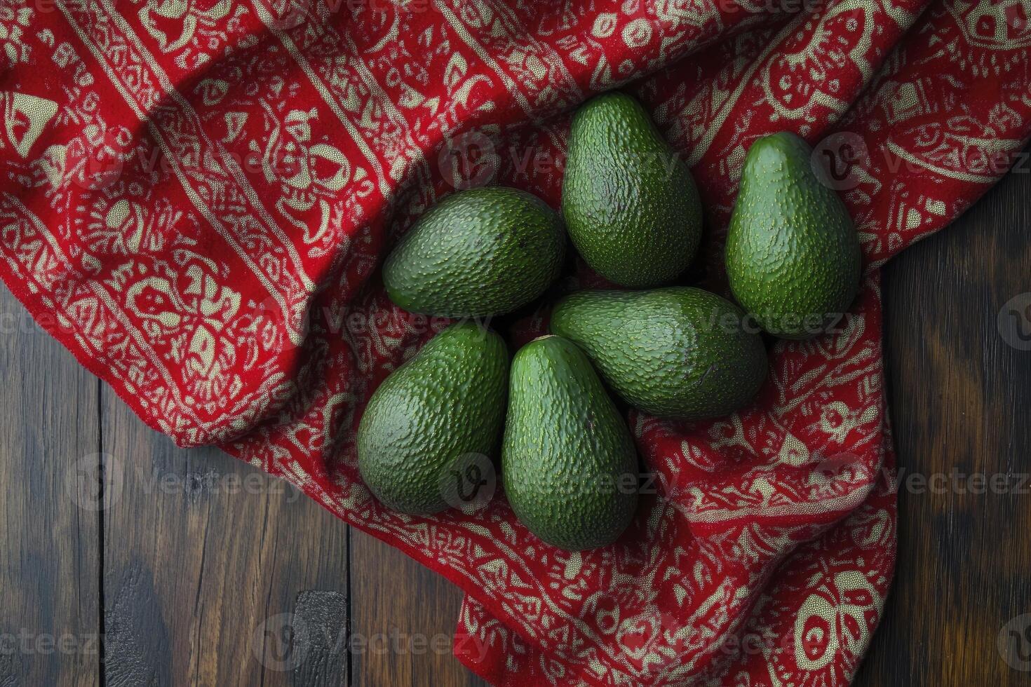 Fresh Avocado Grouping on Red Patterned Cloth Over Rustic Wooden Table photo