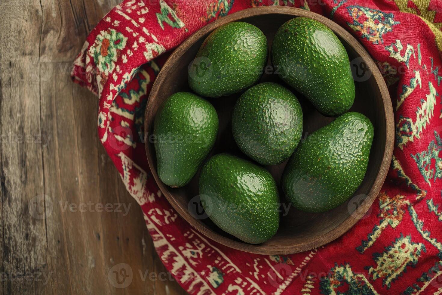 Fresh Avocados in Wooden Bowl on Rustic Table with Textile Background photo