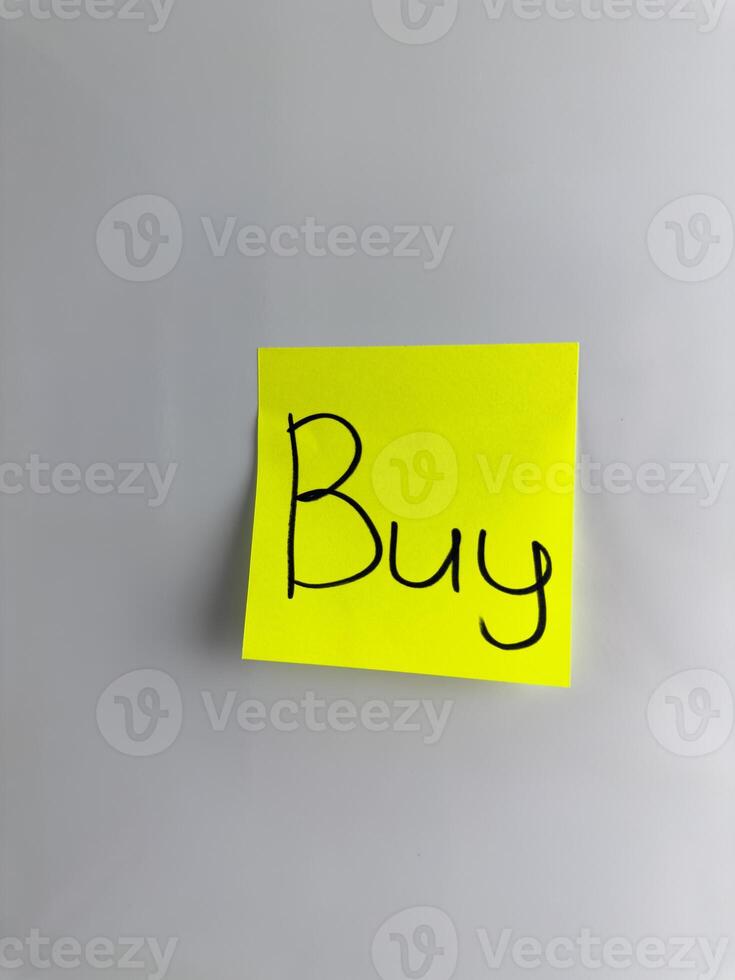 The word Buy is written with marker on sticky note photo