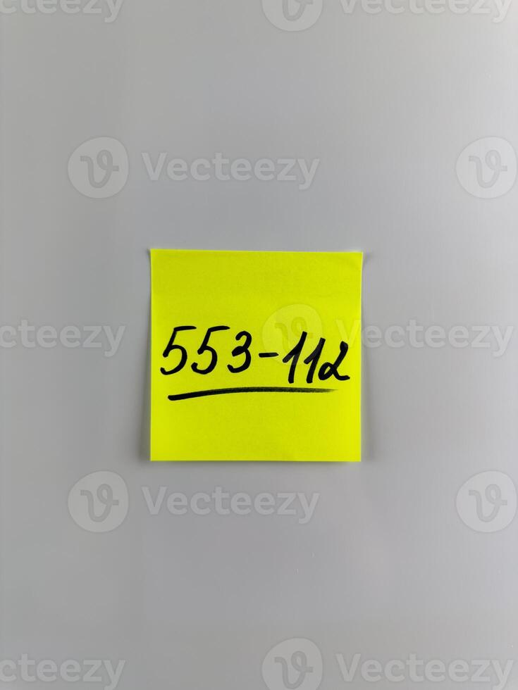 Vertical photo of phone number written on sticky note