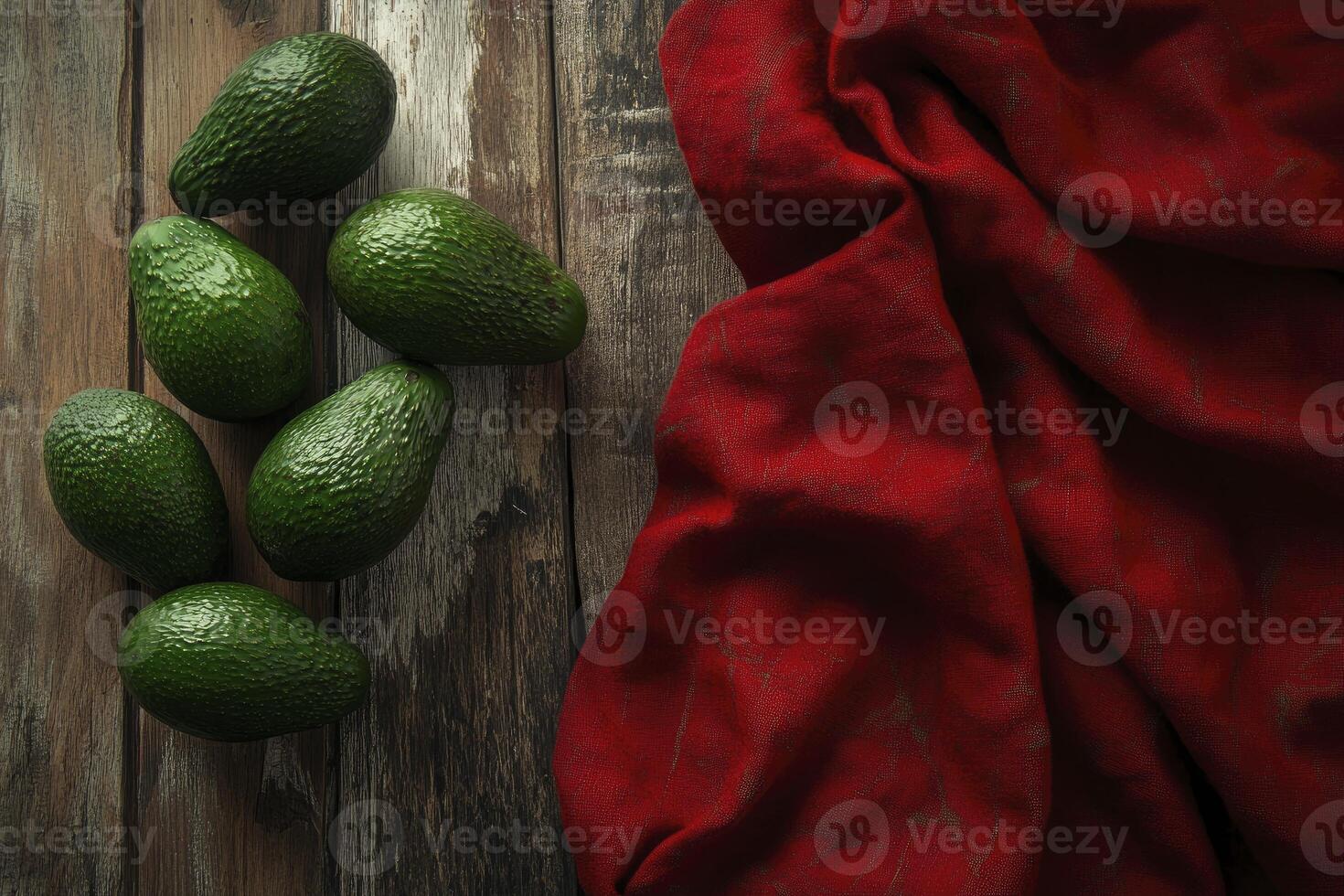 Fresh Avocados on Rustic Wooden Table with Red Fabric Drape photo