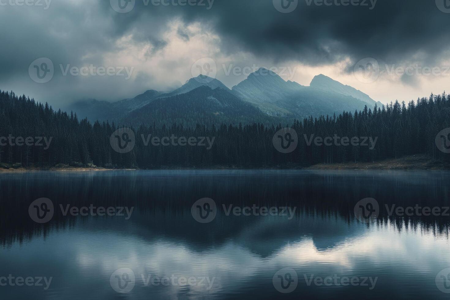Lake Reflection of Mountains and Pine Forest Under Cloudy Moody Sky photo