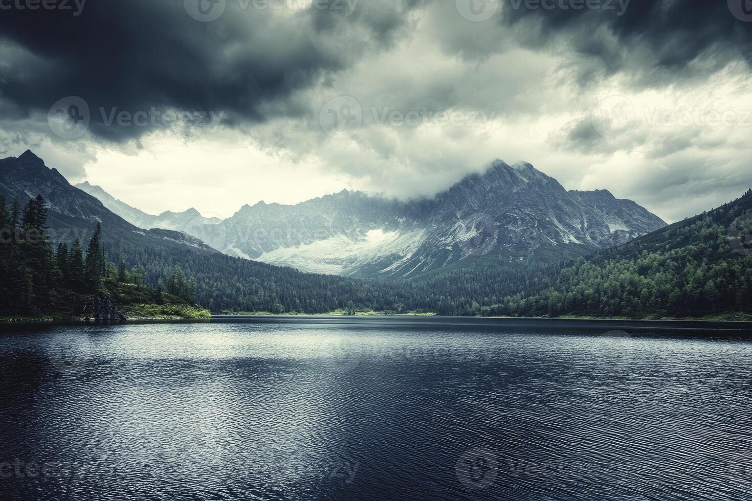 Lake Landscape with Dramatic Cloudy Sky and Mountains in Background photo