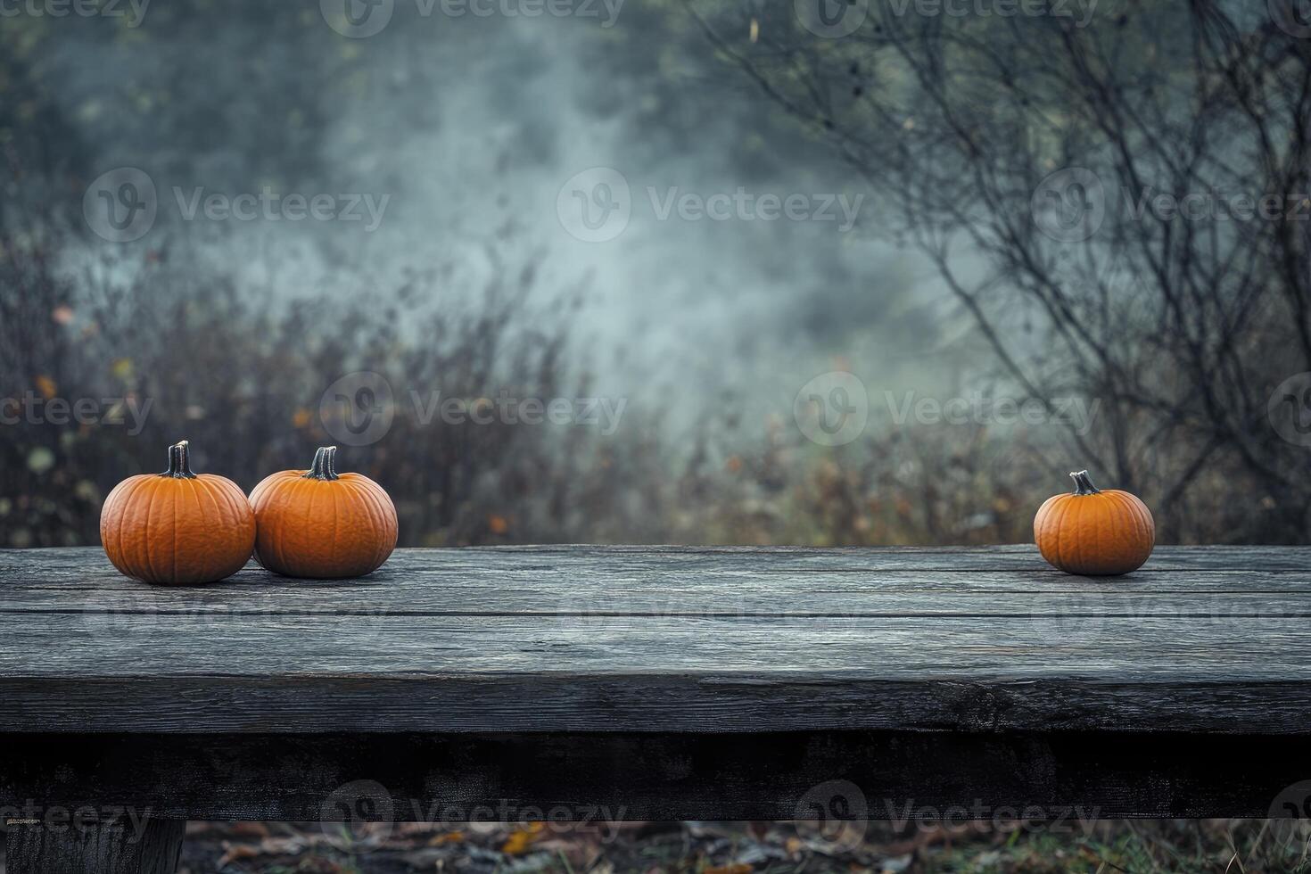 Pumpkins on a Rustic Table in Spooky Autumn Foggy Landscape photo