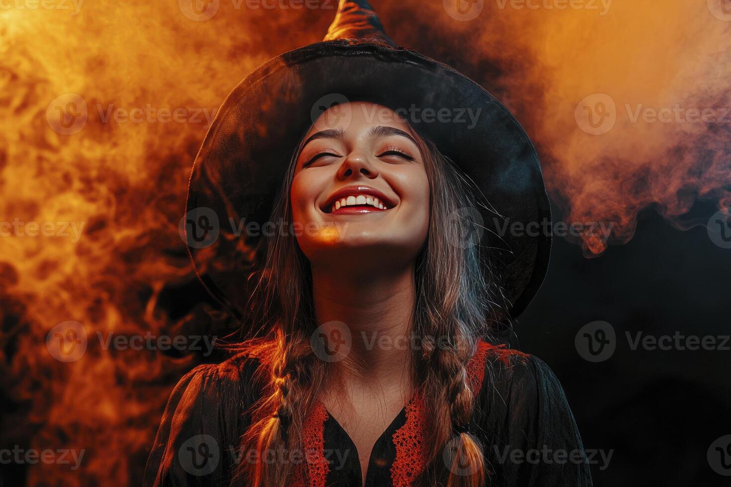 Smiling Witch in Costume Posing with Eyes Closed in Smoky Background photo