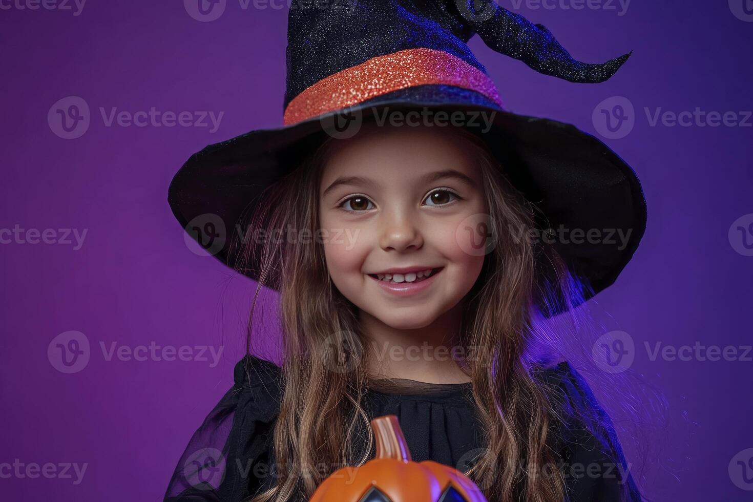 Smiling Girl in Witch Costume Holding Pumpkin Candy Bucket for Halloween photo