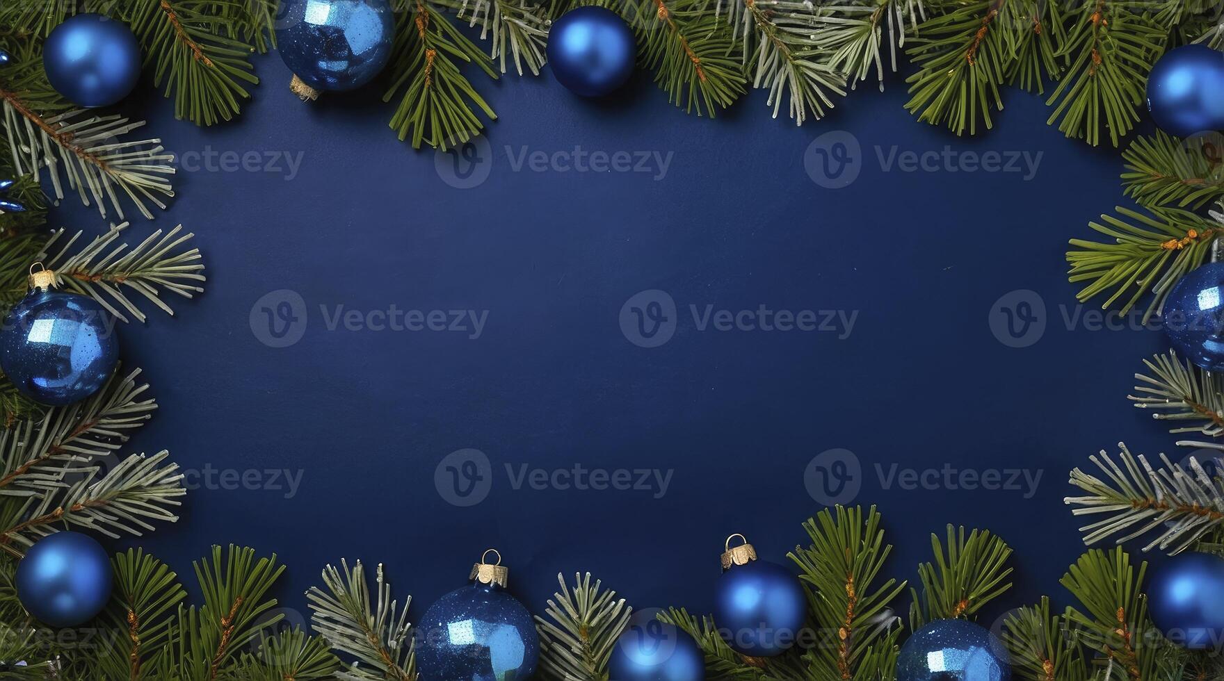 Christmas Ornaments and Evergreen Branches Bordering a Blue Background photo
