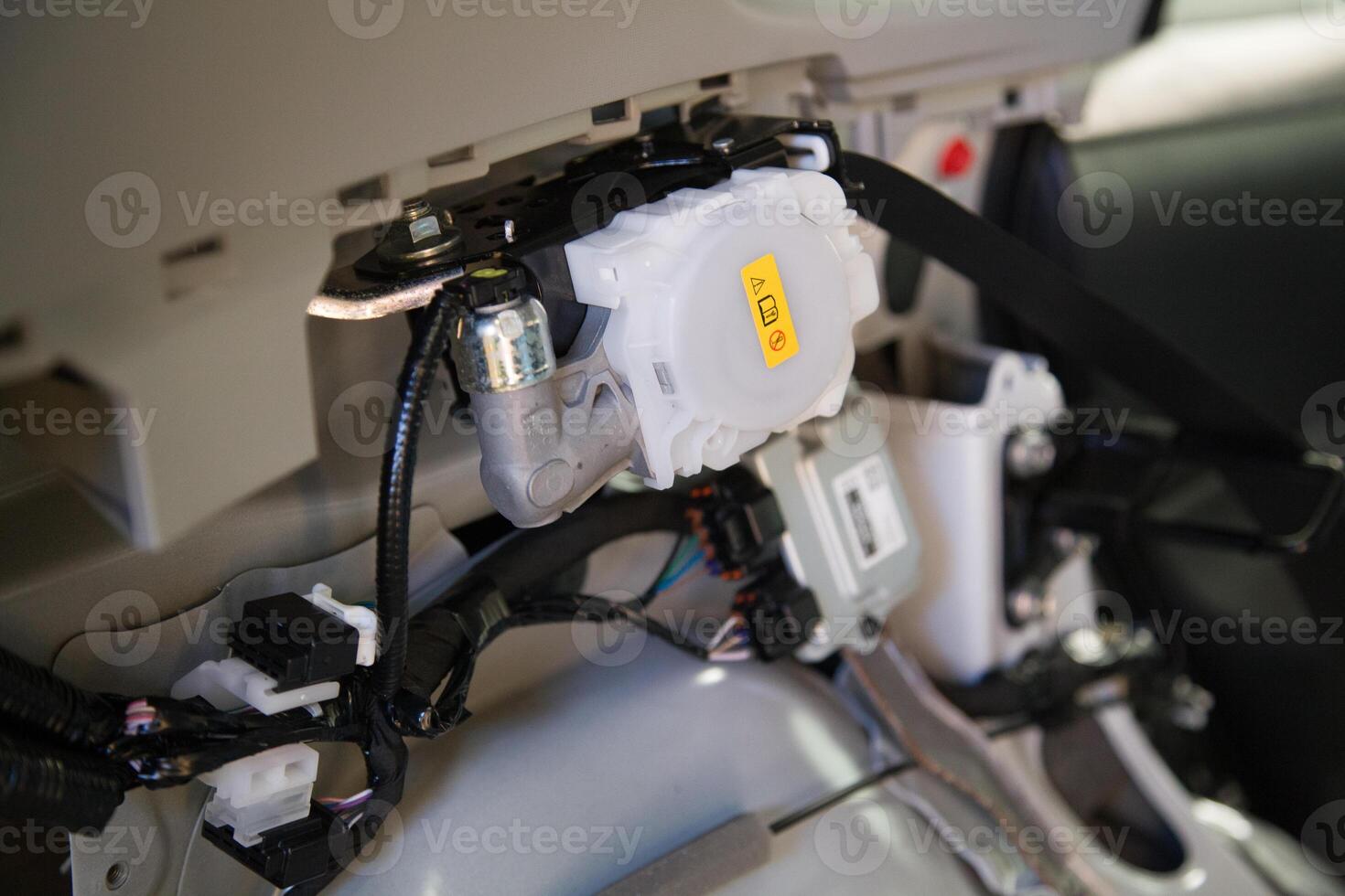 View of a car interior without decorative elements, the rear passenger seatbelt retractor unit in a car, wiring, and other safety-related modules photo