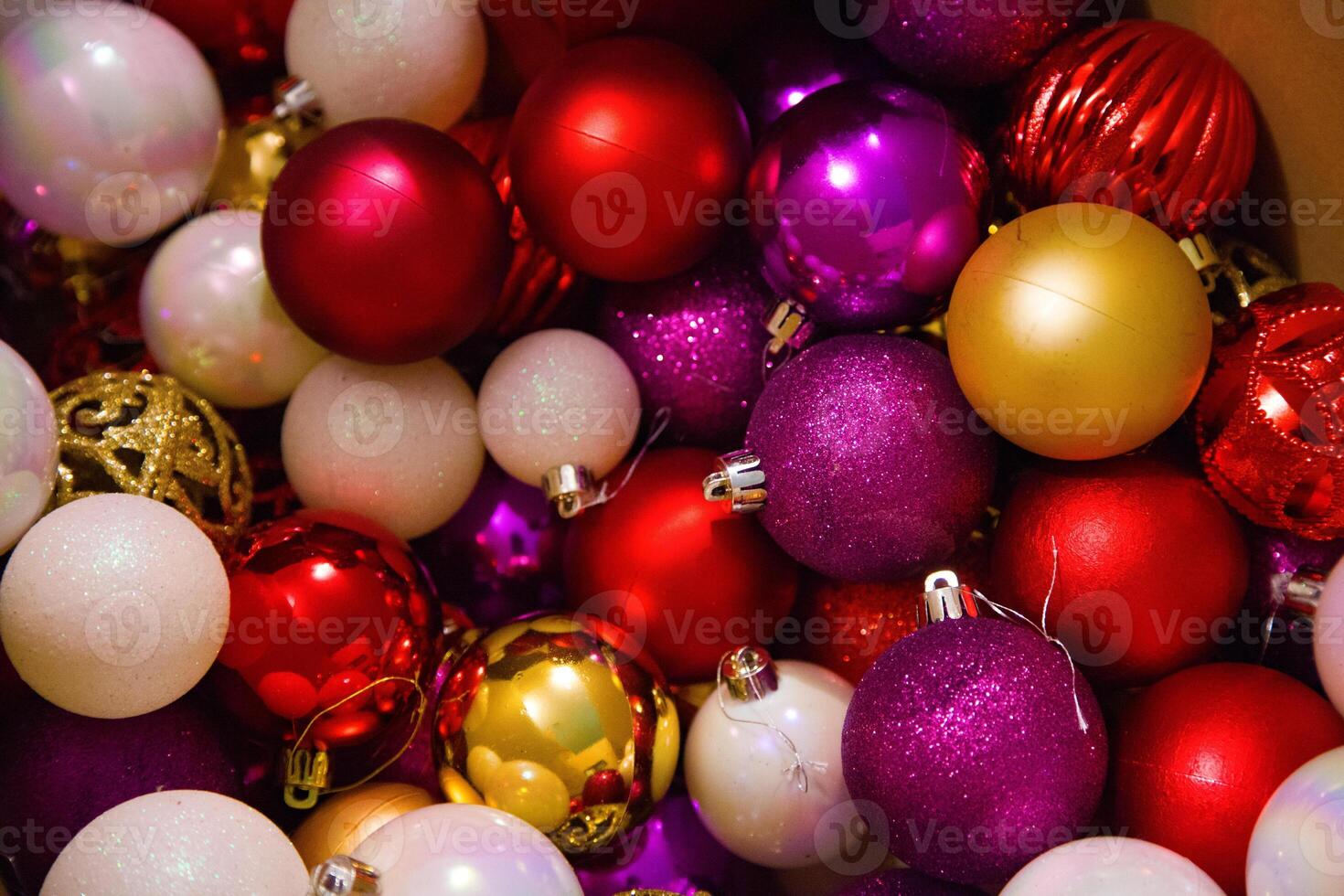 Close-up of colourful Christmas tree ornaments in red, gold, and pink shades for decorating a Christmas tree. photo