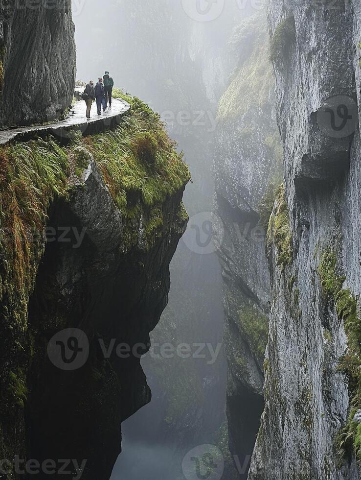 People Walking on Cliff Path Above Steep Canyon in Misty Weather photo