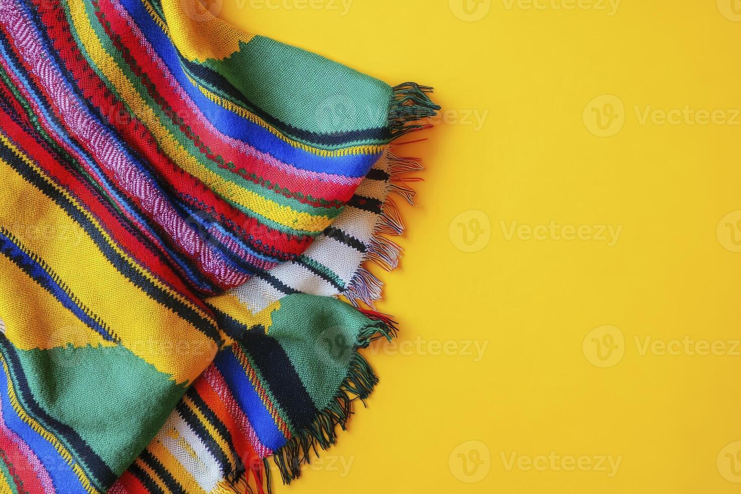 Colorful Striped Blanket with Fringes on a Yellow Background for Copy Space photo