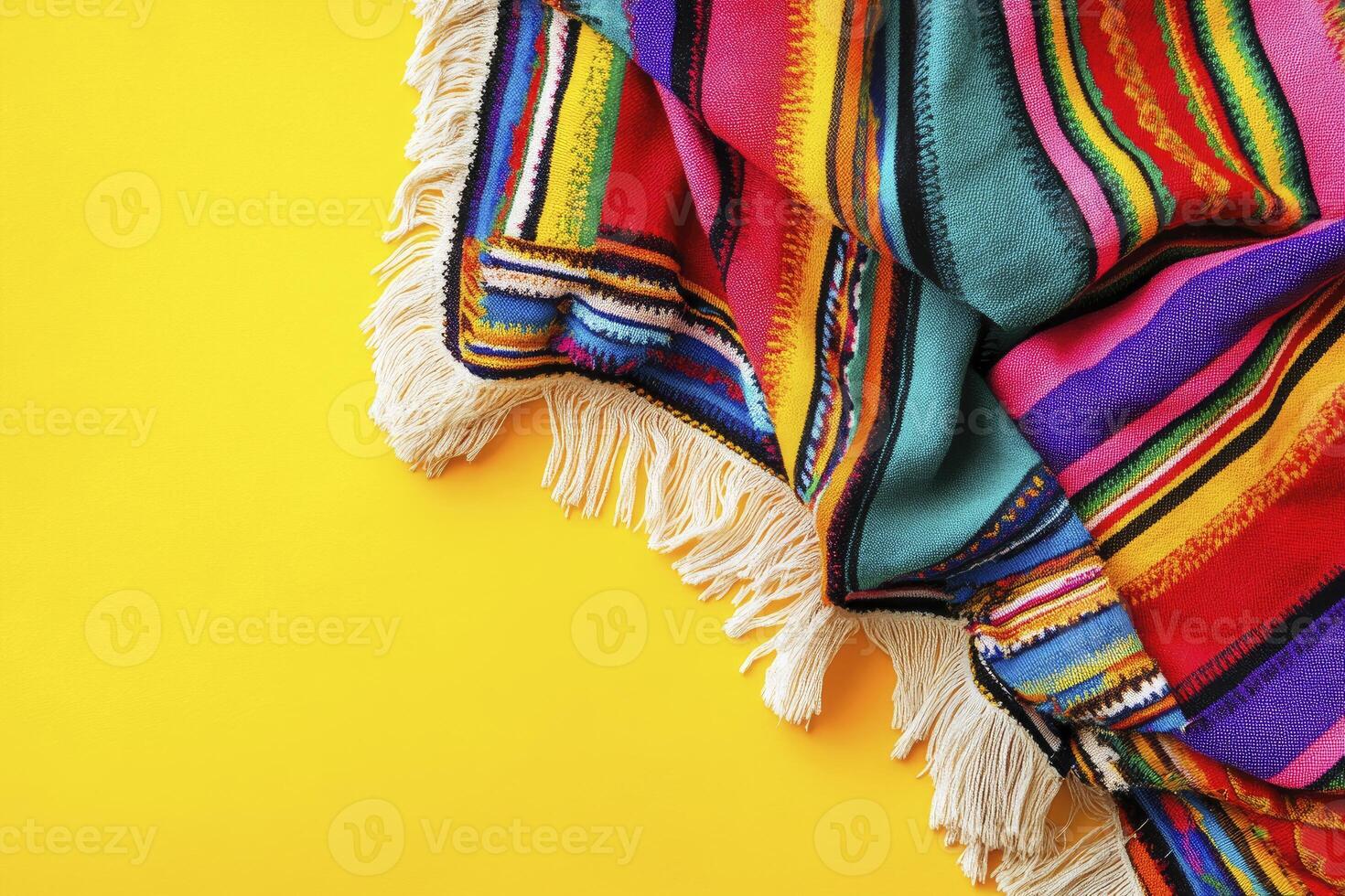 Colorful Striped Blanket with Fringe on Yellow Background Overhead View photo